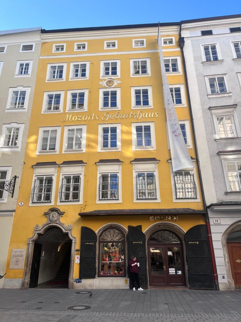 The bright yellow facade of Mozarts Geburtshaus on Getreidegasse, an essential historical stop during a shorter Salzburg walking tour and a highly efficient shorter city tour Salzburg.