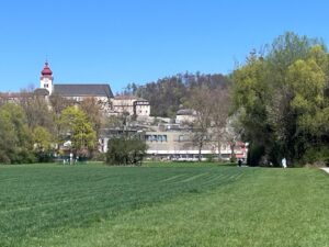 A scenic landscape view of the historic Abbey Nonnberg sitting on a green hillside under a clear blue sky, a highlight location reached during our Sound of Music walking and bus tour Salzburg.