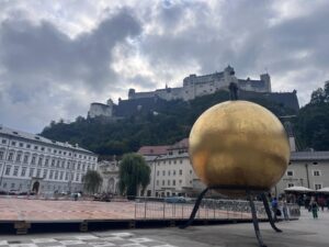 The famous golden sphere in Kapitelplatz with the imposing fortress towering above, where we begin our Fortress Hohensalzburg Tours in Salzburg.