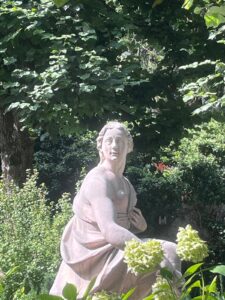 A detailed classical stone statue nestled in the lush greenery of the estate, explored during our exclusive Mirabell Palace Sound of Music Tours in Salzburg.