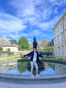 Local expert Annabelle Blanc stands with open arms at the Pegasus Fountain, a major highlight of our Mirabell Palace Sound of Music Tours in Salzburg.